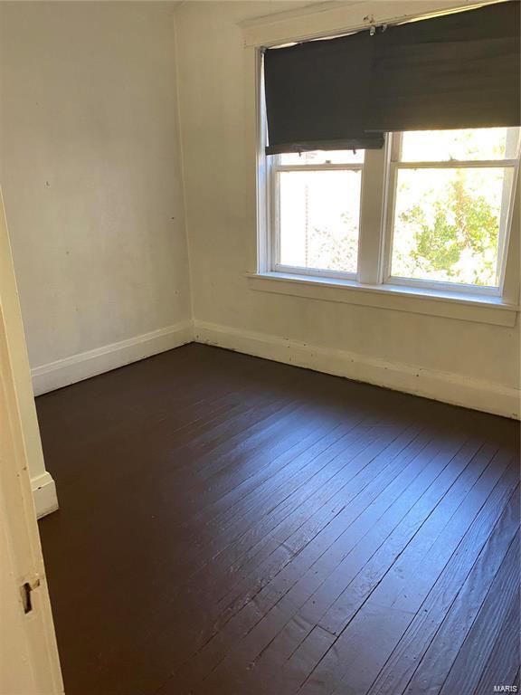 empty room with dark hardwood / wood-style flooring