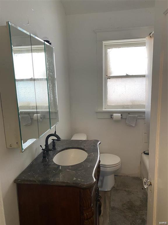 bathroom with hardwood / wood-style floors, vanity, toilet, and a washtub