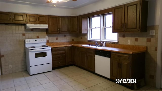 kitchen featuring light tile patterned floors, white appliances, backsplash, and sink