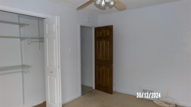 unfurnished bedroom featuring ceiling fan and a closet