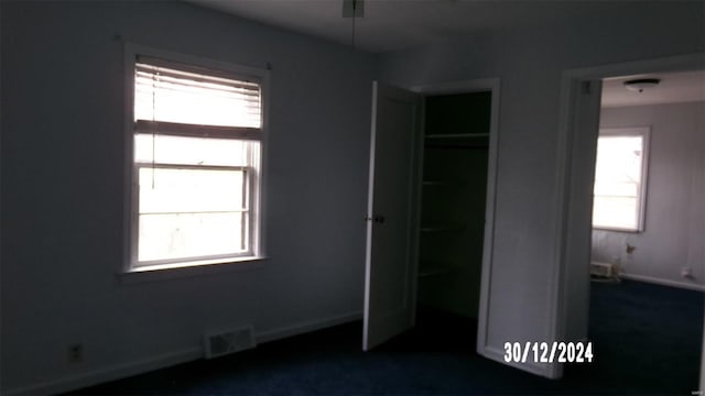 unfurnished bedroom featuring a closet and multiple windows