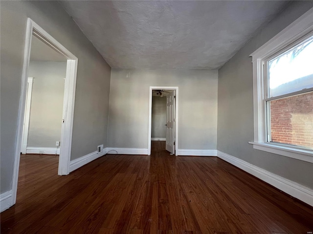 spare room featuring dark hardwood / wood-style flooring, plenty of natural light, and ceiling fan