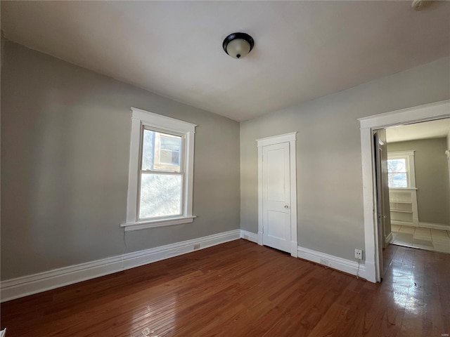 unfurnished bedroom with a closet and dark wood-type flooring