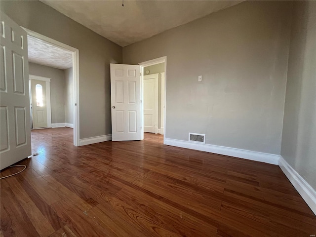 unfurnished bedroom with dark wood-type flooring