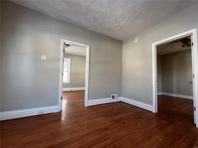 spare room with ceiling fan, dark hardwood / wood-style flooring, and a textured ceiling