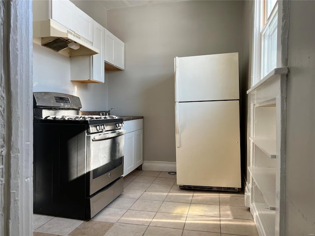 kitchen with white cabinetry, stainless steel gas stove, white fridge, and light tile patterned flooring