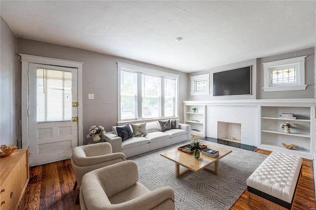 living room featuring dark hardwood / wood-style flooring and a brick fireplace