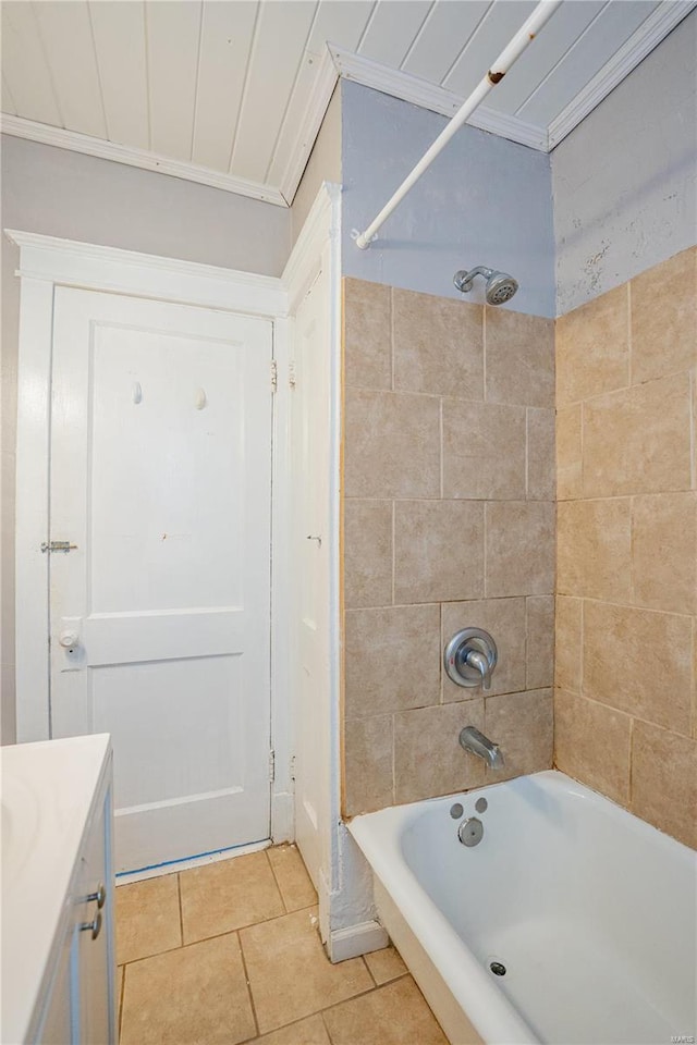 bathroom with tile patterned flooring, vanity, crown molding, and tiled shower / bath