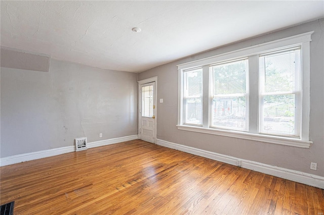 unfurnished room with hardwood / wood-style floors