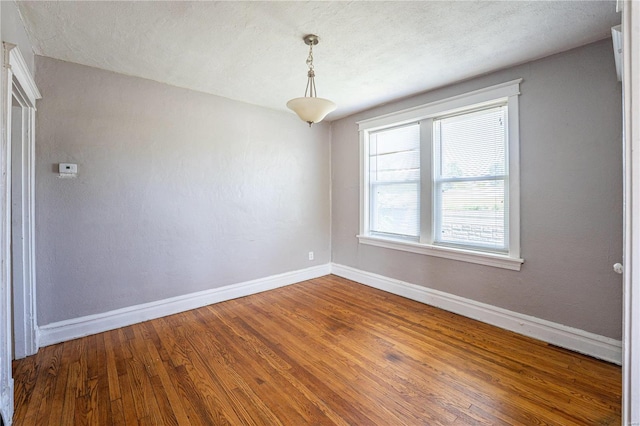 spare room featuring hardwood / wood-style floors and a textured ceiling