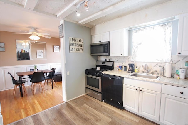 kitchen featuring white cabinets, appliances with stainless steel finishes, and light hardwood / wood-style flooring