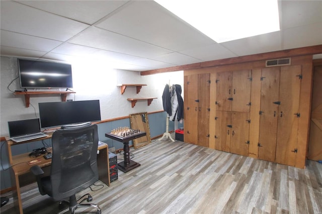 home office featuring a paneled ceiling and light hardwood / wood-style flooring