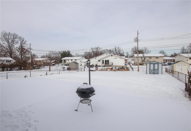 snowy yard featuring a shed