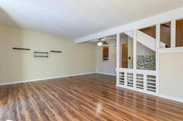 empty room featuring a textured ceiling, dark hardwood / wood-style flooring, and ceiling fan