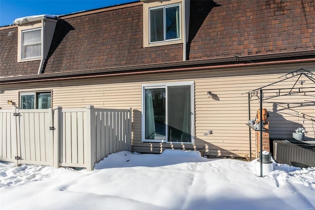 view of snow covered back of property