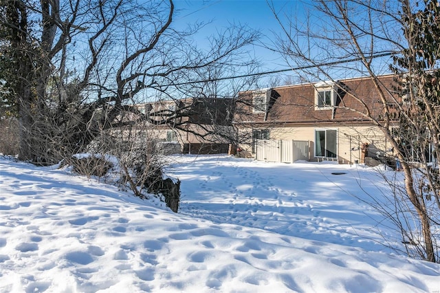 view of snow covered back of property