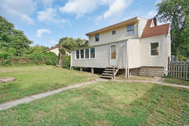 rear view of house featuring a yard