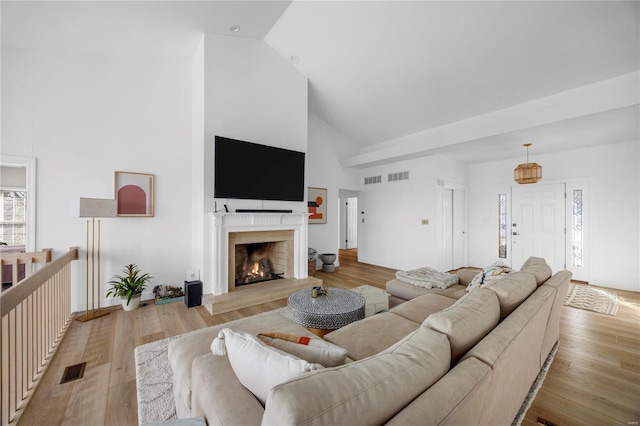 living room featuring lofted ceiling and light hardwood / wood-style flooring