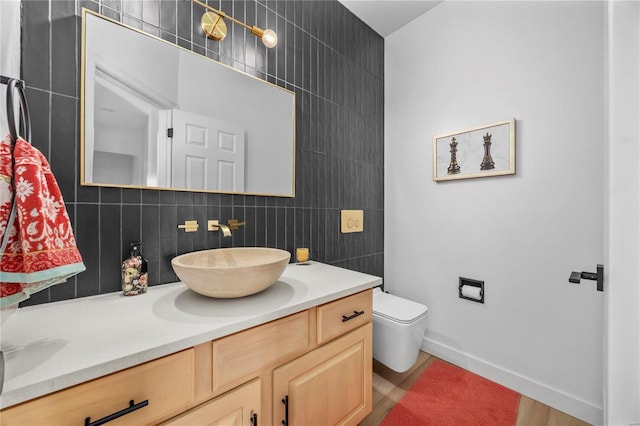 bathroom featuring toilet, vanity, and backsplash