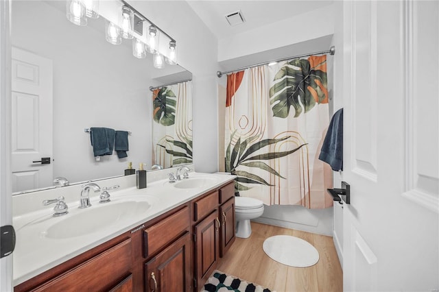 full bathroom featuring shower / bath combo with shower curtain, toilet, vanity, and wood-type flooring