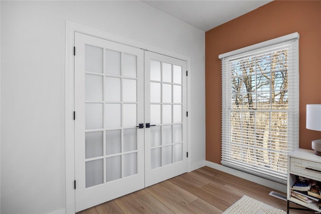 doorway with light hardwood / wood-style floors, french doors, and plenty of natural light