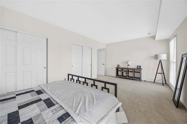 carpeted bedroom featuring multiple closets