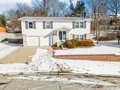 bi-level home with concrete driveway and an attached garage