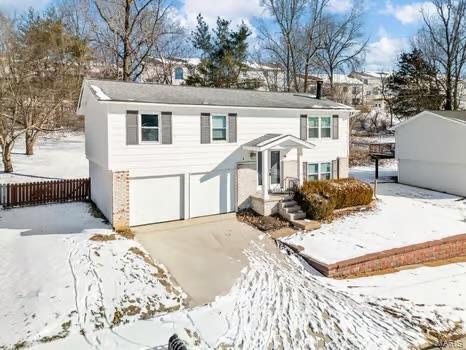 raised ranch featuring a garage and driveway