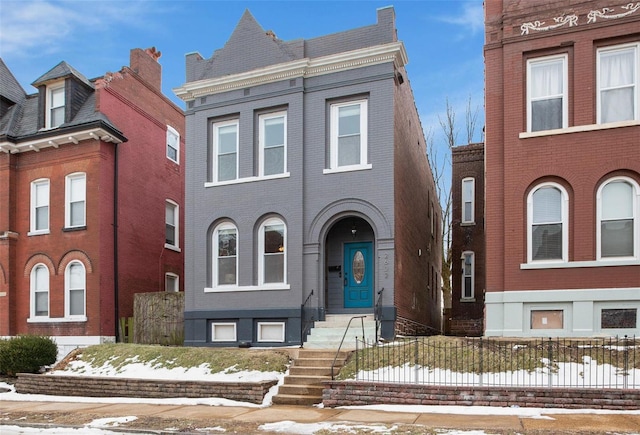 view of front of house featuring fence and brick siding