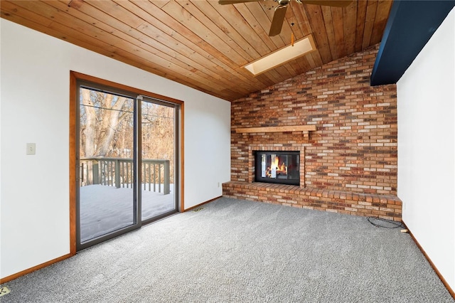 unfurnished living room featuring ceiling fan, wooden ceiling, lofted ceiling with skylight, and carpet