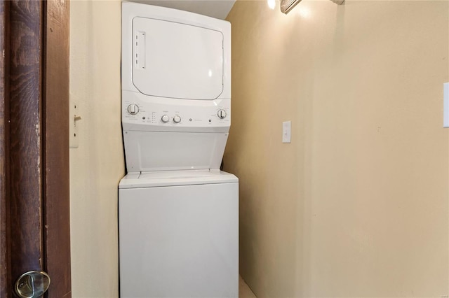 laundry room featuring stacked washer / drying machine