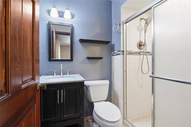 bathroom featuring toilet, walk in shower, and vanity