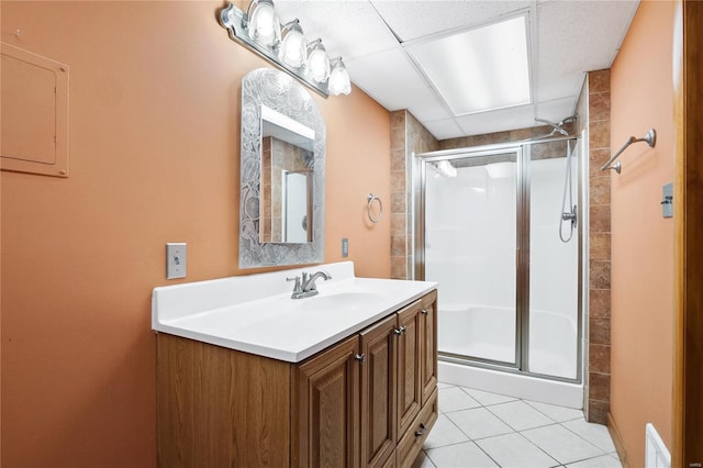 bathroom with tile patterned flooring, a shower with door, and vanity