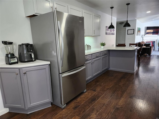 kitchen featuring dark hardwood / wood-style flooring, hanging light fixtures, stainless steel fridge, gray cabinets, and kitchen peninsula