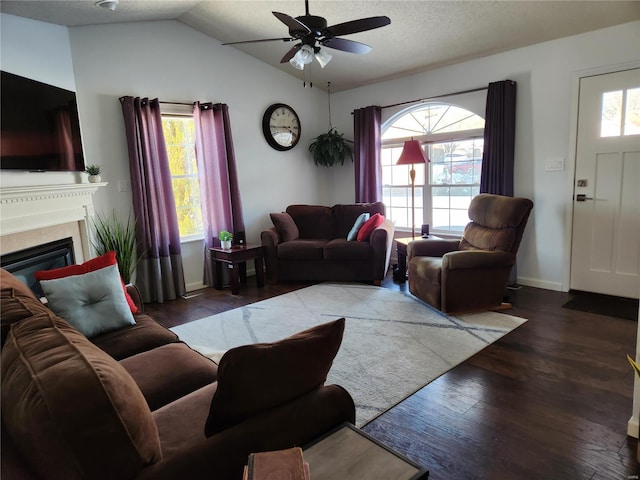 living room featuring ceiling fan, dark wood-type flooring, a wealth of natural light, and lofted ceiling