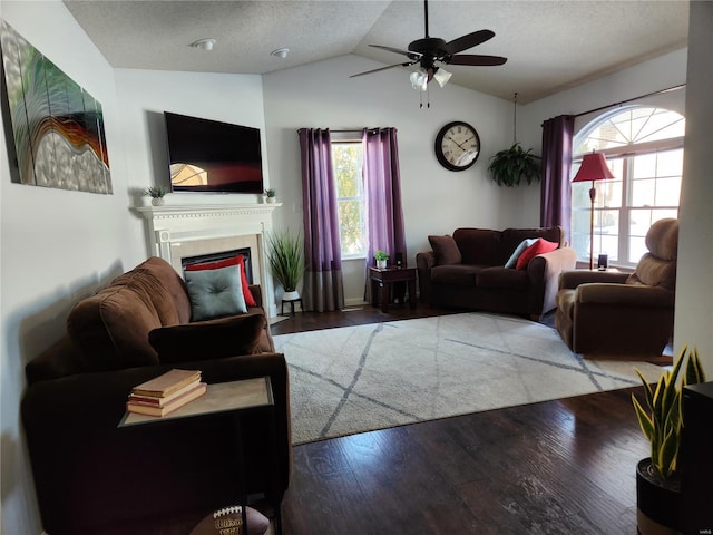 living room with vaulted ceiling, ceiling fan, a wealth of natural light, and hardwood / wood-style floors