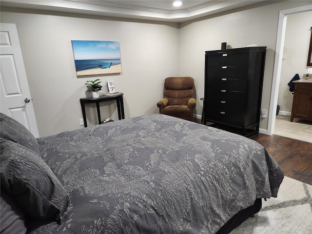 bedroom with dark hardwood / wood-style flooring and ornamental molding