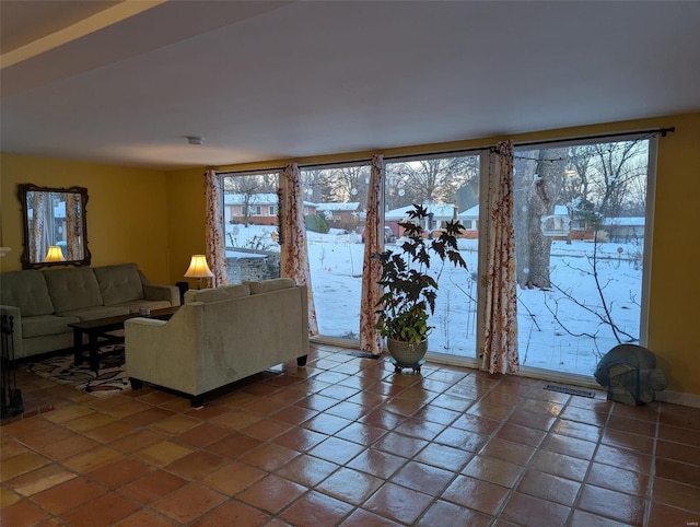 living room with dark tile patterned floors and a healthy amount of sunlight