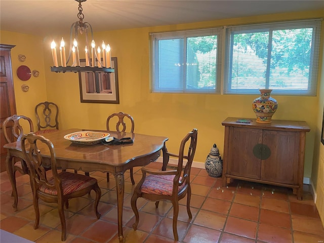 dining area featuring tile patterned floors and an inviting chandelier