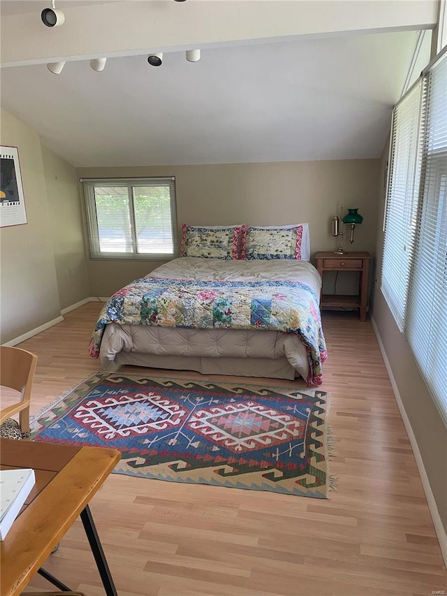 bedroom featuring wood-type flooring and vaulted ceiling