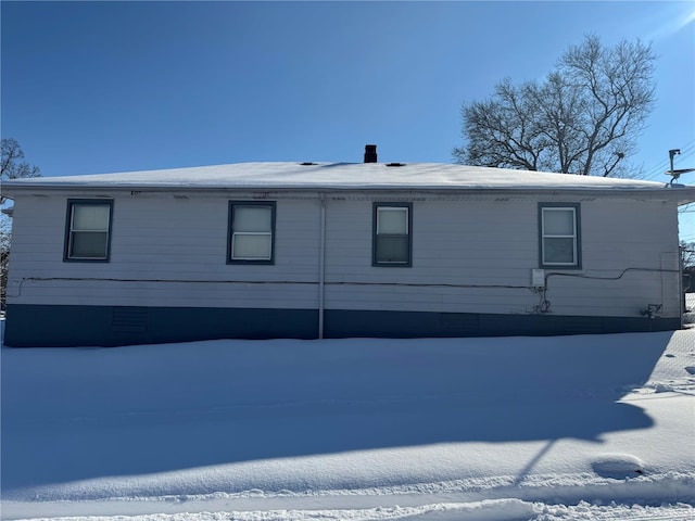 view of snow covered rear of property