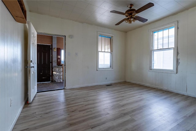 empty room with ceiling fan and light hardwood / wood-style flooring