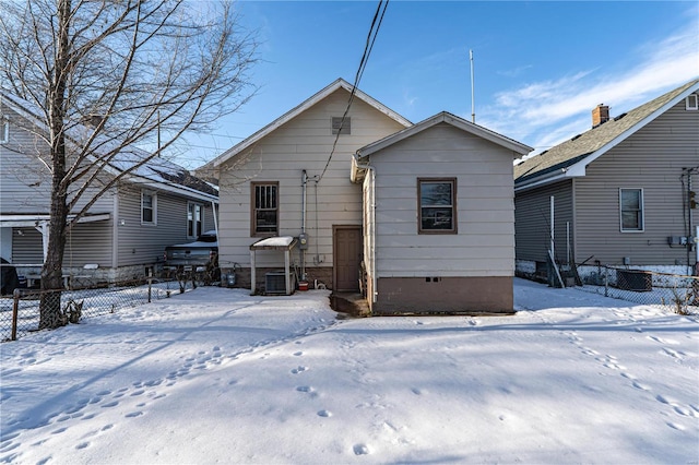 snow covered rear of property with central AC unit