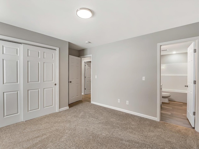 unfurnished bedroom featuring light carpet, connected bathroom, and a closet