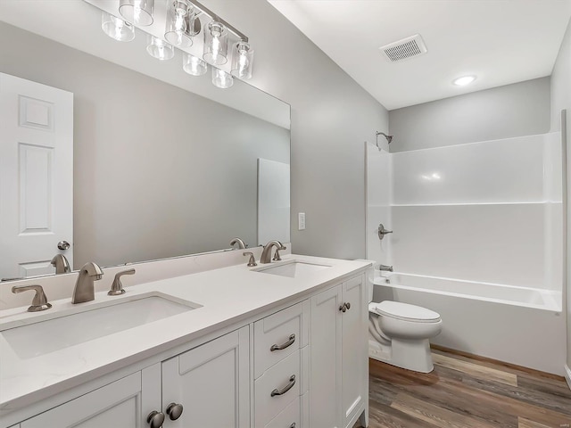 full bathroom with shower / tub combination, vanity, hardwood / wood-style flooring, and toilet