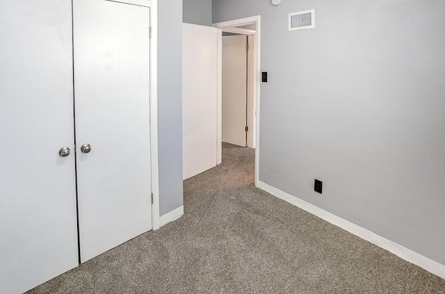 unfurnished bedroom featuring carpet and a closet