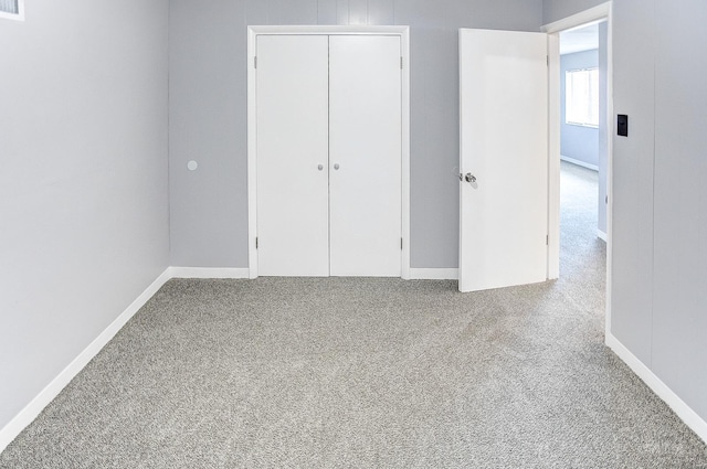 unfurnished bedroom with light carpet and a closet