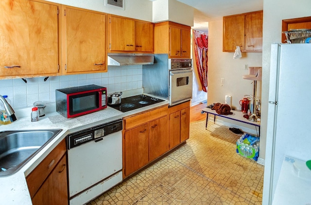 kitchen featuring sink, white appliances, and backsplash