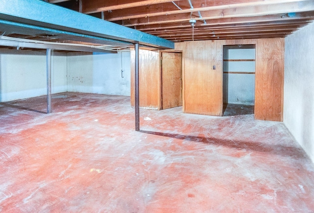 basement featuring wooden walls