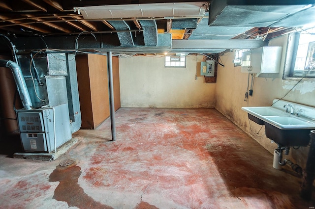 basement featuring heating unit, electric panel, and sink